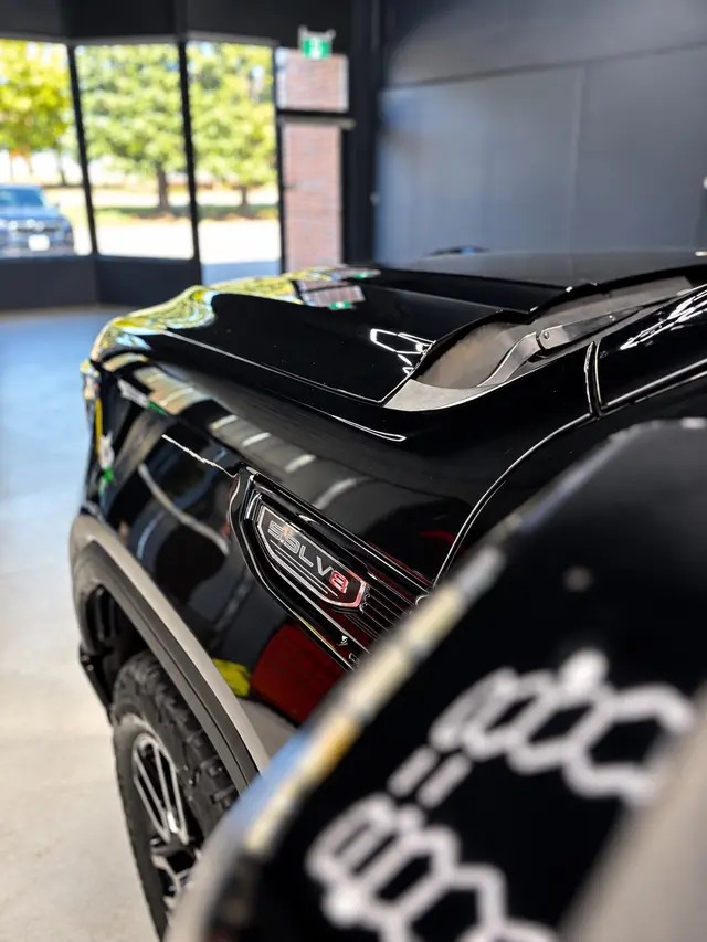 Close-up of the black truck's reflective paint finish in the studio