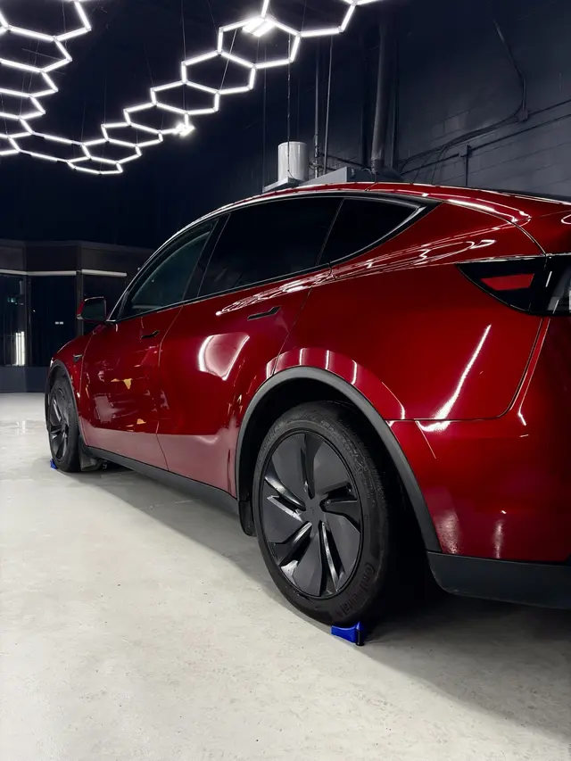 Rear quarter and reflective red paint on the completed Tesla Model Y